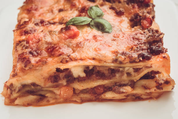 istock Homemade Lasagna with Minced Beef, Tomato Sauce and Fresh Basil on White Plate 980968490