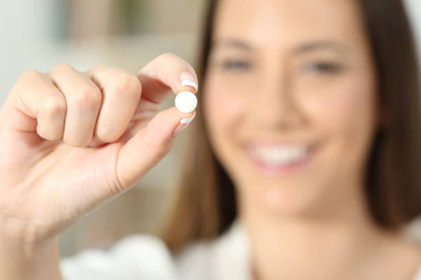 istock Happy woman hand showing a pill 980969792