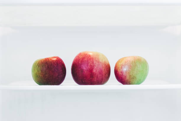 three apples - three different refrigerators imagens e fotografias de stock