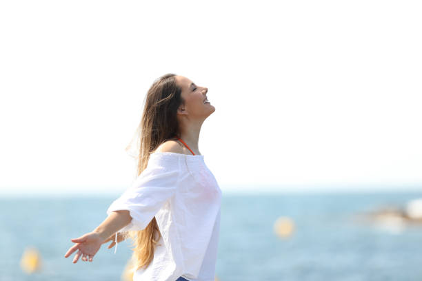 relajado mujer respirando aire fresco en la playa - beach sea zen like nature fotografías e imágenes de stock