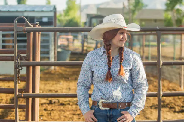 redhat cowgirl with hat smiling at ranch in Salt Lake City SLC Utah USA