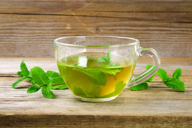 istock Fresh organic mint tea in glass on wooden table. 980986382