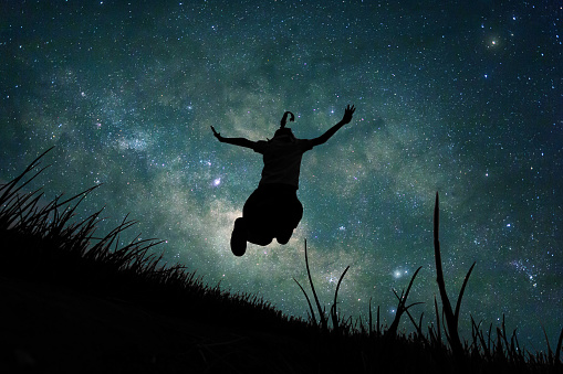 Young girl jumping into space, silhouette image. Concept Knowledge, astronaut, astronomer mystery story.