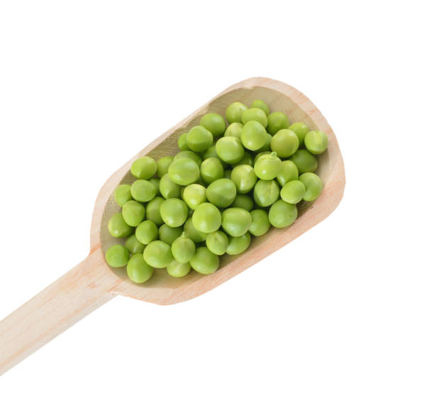 istock fresh green peas in wood spoon isolated on a white background. 980993718