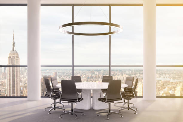 istock Office interior with large round desk and chairs with view at Empire state building 981003082