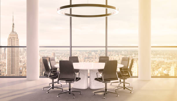 istock Office interior with large round desk and chairs with view at Empire state building 981003086