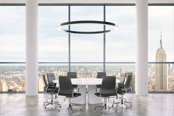 istock Office interior with large round desk and chairs with view at Empire state building 981003088