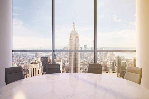 istock Office interior with large round desk and chairs with view at Empire state building 981003090