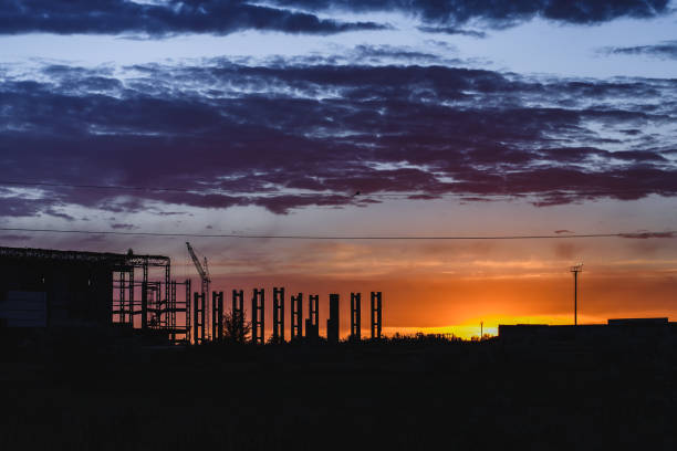 istock Crane and industrial construction site against sunset, beautiful evening sky. 981003422
