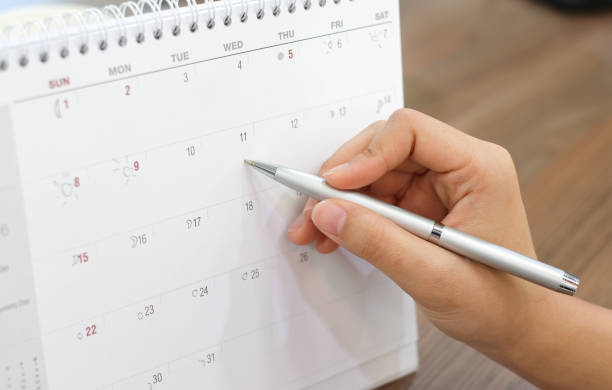 istock close up on woman hand with pen writing on calender for note or make appointment concept. 981020080