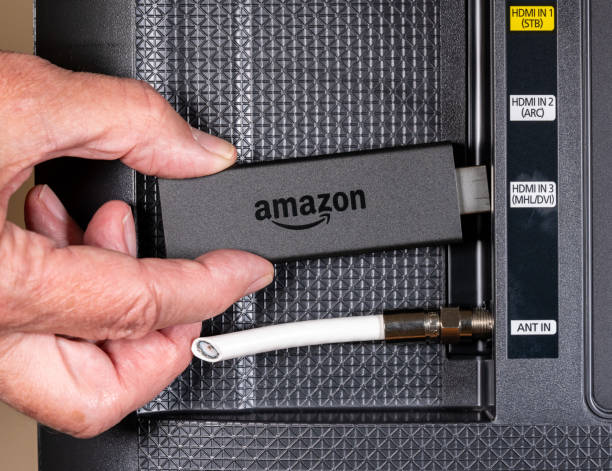 uomo anziano che inserisce a mano il dispositivo amazon fire tv - serie televisiva foto e immagini stock