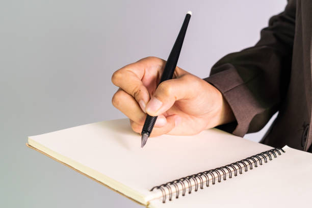 istock Business man hand holding pen writing on paper 981029796