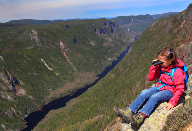 Girl hiker sitting and admiring the landscape from the summit of Acropoles des Draveures, Hautes-Gorges-de-la-Rivière-Malbaie National Park Girl hiker sitting and admiring the landscape from the summit of Acropoles des Draveures, Hautes-Gorges-de-la-Rivière-Malbaie National Park, Quebec, Canada charlevoix photos stock pictures, royalty-free photos & images