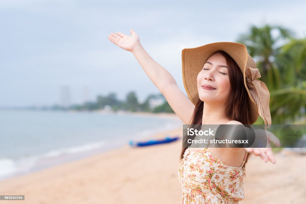 Young Asian woman with hat enjoying at the beach. Summer,vacation and holiday concept Adult Stock Photo