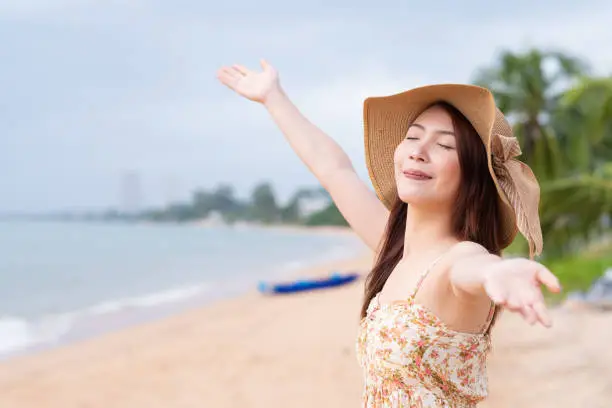 Young Asian woman with hat enjoying at the beach. Summer,vacation and holiday concept