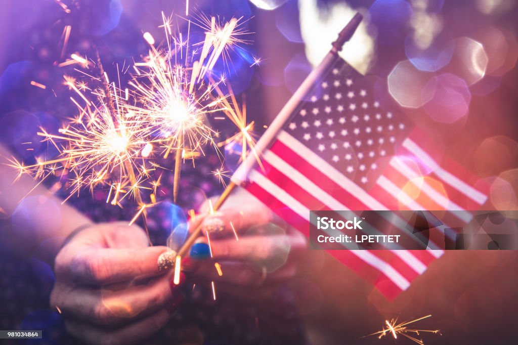 Fourth of July Fourth of July scene with sparklers and the American flag. Photographed in low light using the Canon EOS 1DX Mark II Fourth of July Stock Photo