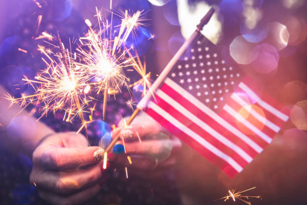 Fourth of July Fourth of July scene with sparklers and the American flag. Photographed in low light using the Canon EOS 1DX Mark II fourth of july stock pictures, royalty-free photos & images