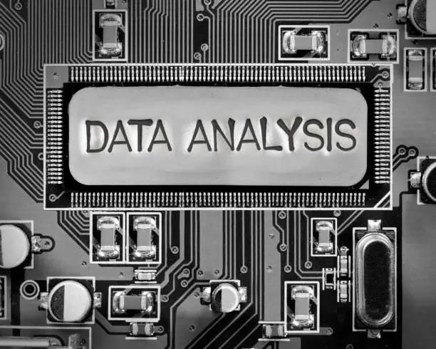 Macro photo of circuit board and chip with DATA ANALYSIS words imprinted on metal surface