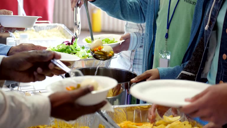 Busy group of volunteers serving community in soup kitchen