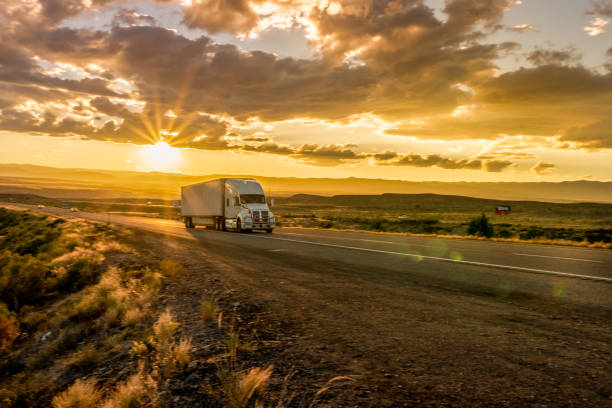 semi-truck on an interstate highway at dusk with cloudscape - speed horizontal commercial land vehicle automobile industry imagens e fotografias de stock