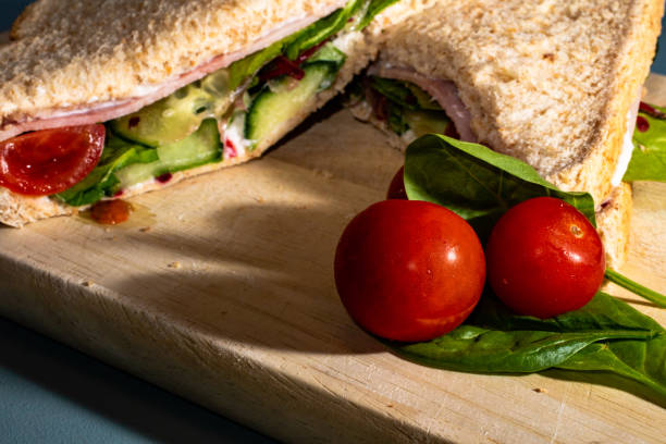 istock Two tomatoes close up with a sandwich in the background 981058054