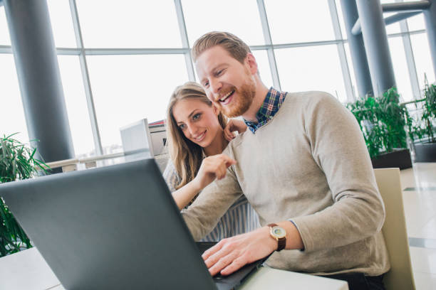 istock Young couple hugging and looking at laptop 981068430