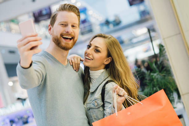 istock Joyful couple in love taking a selfie while shopping 981069194