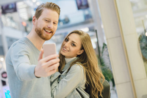 istock Young couple taking a selfie wile shopping at the mall 981069270