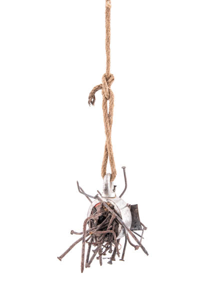 istock Two-way steel search magnet with rusty nails hanging on a rope, isolated on white background 981079400