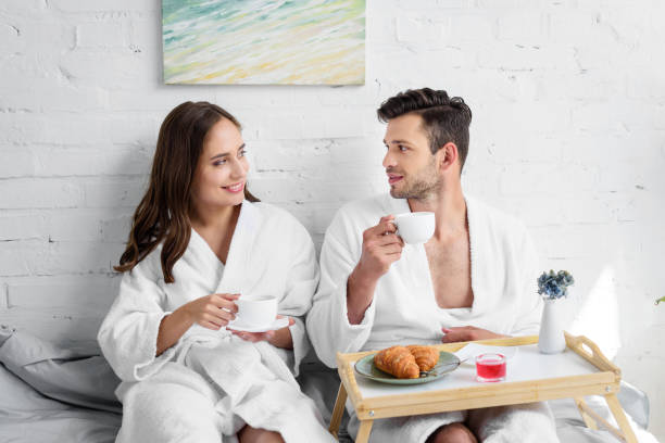 istock young couple in bathrobes having breakfast in bed in morning 981079472