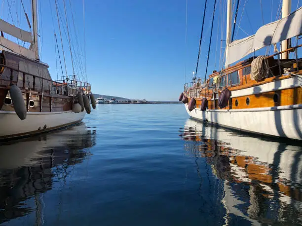 Two boats docked at the Bodrum marina and view of blue sea
