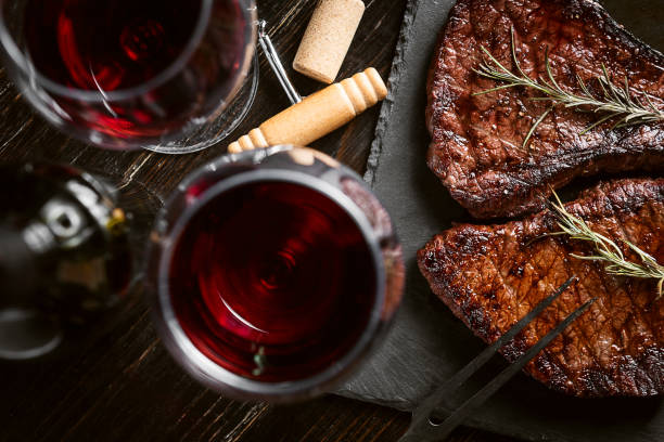 steaks from fresh meat dinner for two with steaks and red wine fork silverware table knife fine dining stock pictures, royalty-free photos & images