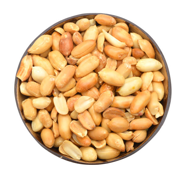 istock Processed peanuts isolated in wood bowl on white background 981092504