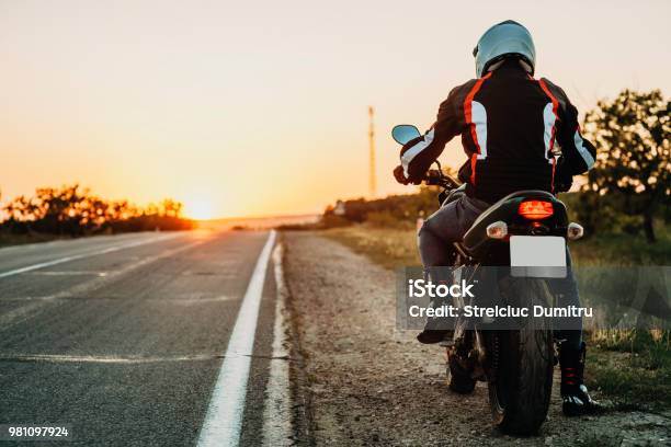 Man On Motorbike Riding On Roadside Stock Photo - Download Image Now - Motorcycle, Biker, Rear View