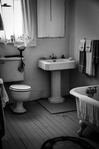 A turn of the century (20th century) bathroom in black and white.