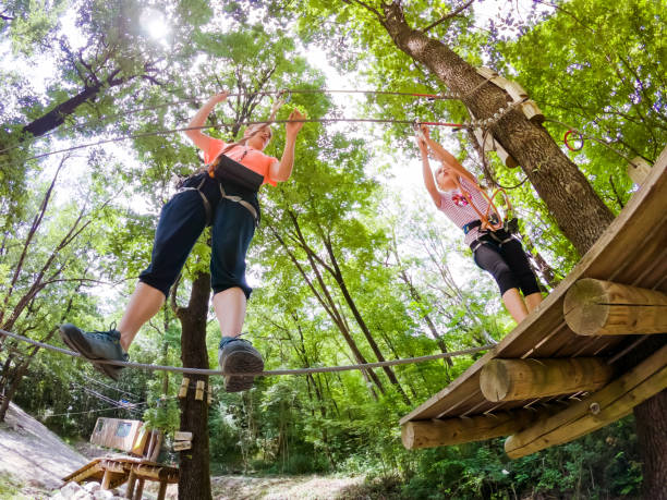 istock Assistant Looking Over a Young Girl Enjoying in Fun Park in Forest 981108584