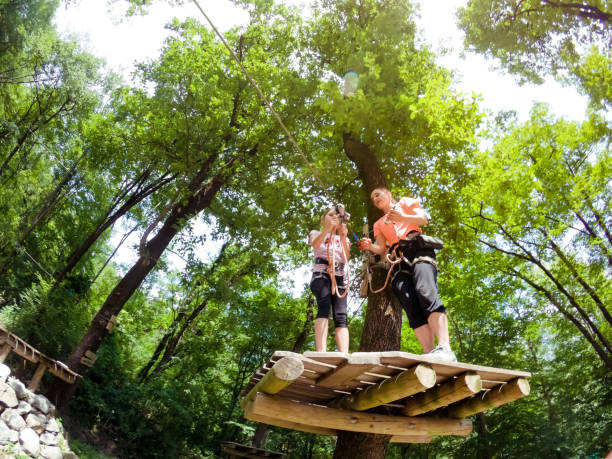 istock Assistant Looking Over a Young Girl Enjoying in Fun Park in Forest 981108618