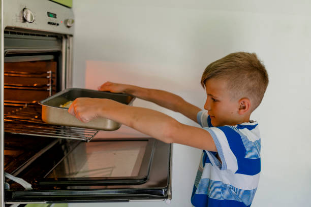 istock Young boy put a pizza in oven 981109126