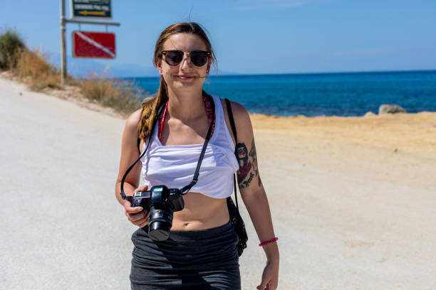 istock Young Woman Photographer on Beach 981116728