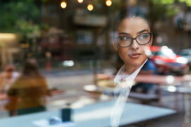 ritratto di imprenditrice che guarda fuori dalla finestra - looking through window window business women foto e immagini stock