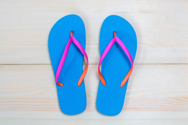 istock Blue flip flops isolated on wooden background. Top view 981128682