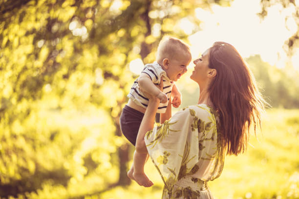 istock Young Mother with her baby boy playing at nature. 981132954