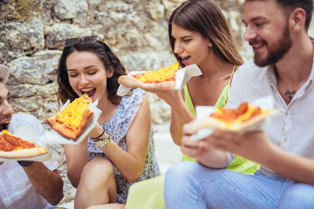 istock Happy people eating fast food in city while travelling 981138904