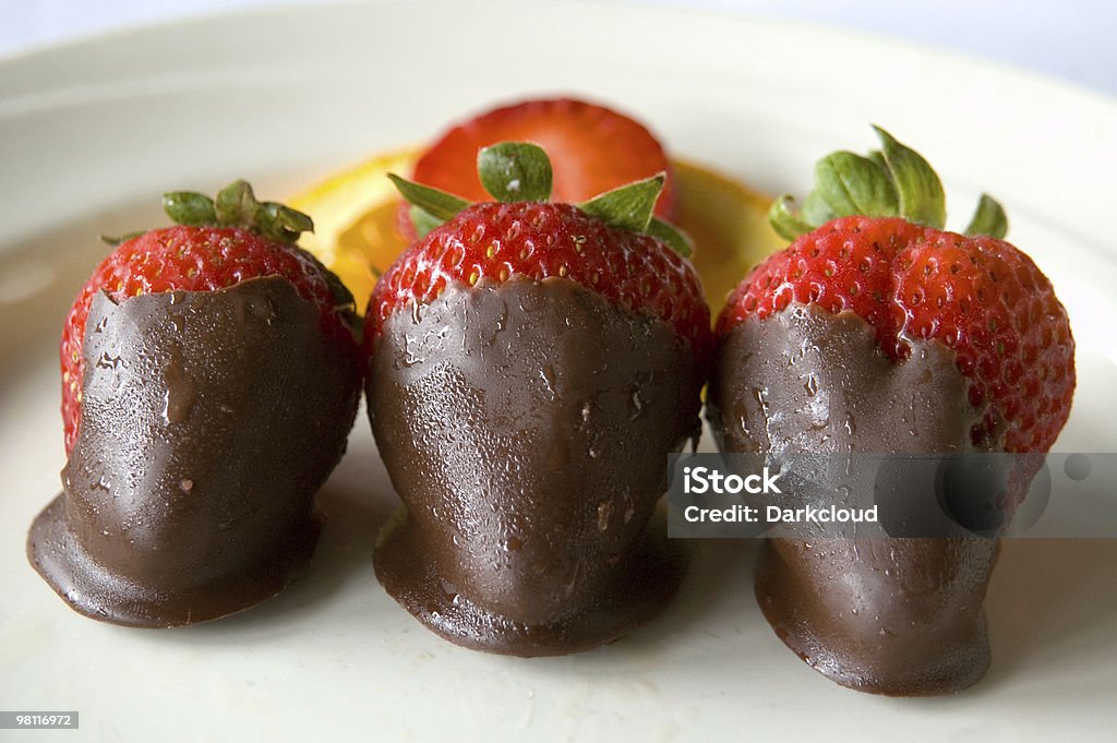 Glistening strawberries dipped in chocolate Three chocolate covered starberries on display.  Antioxidant Stock Photo