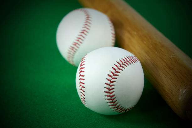 2 つの白野球ボールとグリーンに分離された木製のバットを感じた背景 - baseball baseball bat bat isolated ストックフォトと画像