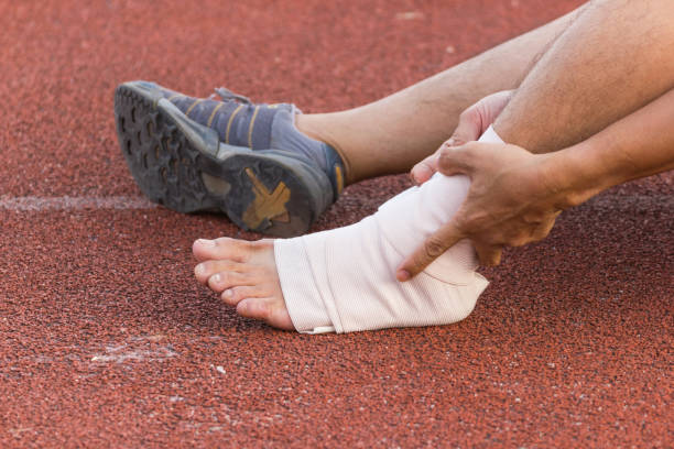 istock Male athlete applying compression bandage onto ankle injury 981176524