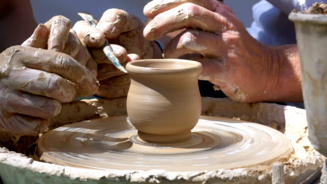 Hands of the Master Potter and Vase of Clay on the Potter's Wheel