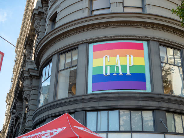 ropa gap tienda insignia en el escaparate en el esquema de color de gay pride - homosexual gay pride business rainbow fotografías e imágenes de stock