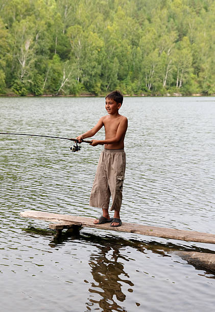 istock boy fishing with spinning 98121796
