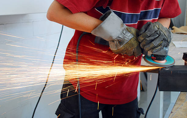 istock Industrial worker grinding metal with sparks flying out 98121856